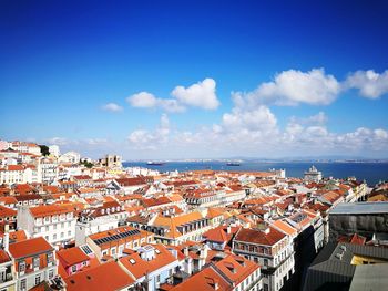 High angle view of townscape by sea against sky