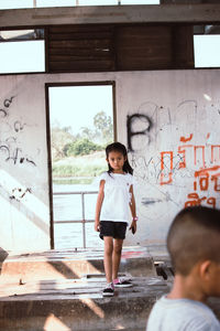 Portrait of boy standing against wall