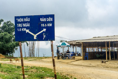 Information sign on road against sky