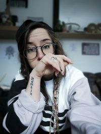 Portrait of young woman wearing eyeglasses at home