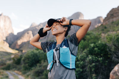 Happy woman standing against mountain