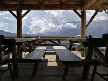 Empty chairs and table against sky