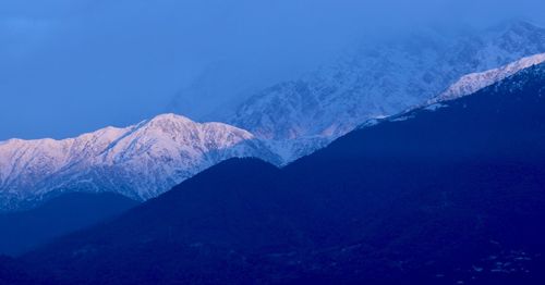Scenic view of snowcapped mountains against clear blue sky
