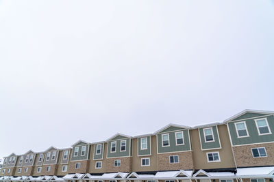 Low angle view of buildings against sky during winter