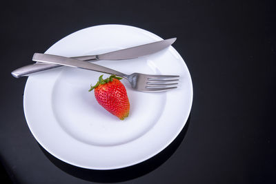 Fruits in plate against black background