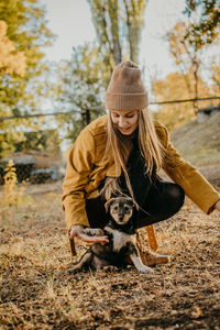 Pet love. volunteer woman plays with homeless puppies in the autumn park. authentic moments of joy