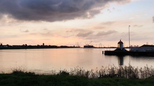 Scenic view of river by buildings against sky