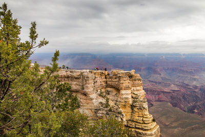 Rock formations on landscape against cloudy sky