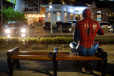 View of statue on street in city at night