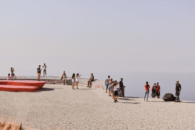 People on beach against clear sky