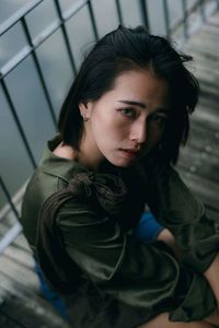 High angle portrait of woman sitting against railing