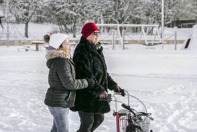 Senior woman with female home caregiver walking at winter