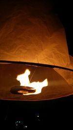 Close-up of lit candle in dark room