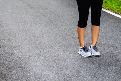 Low section of woman standing on street