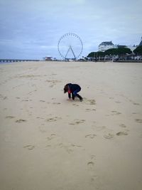 Man with umbrella on beach against sky