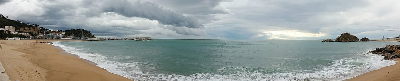 Panoramic view of beach against cloudy sky