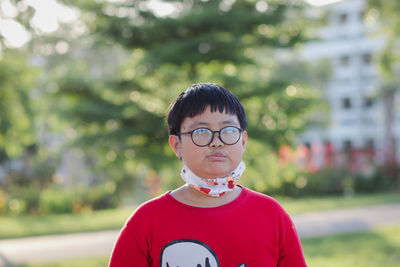 Close-up of boy wearing eyeglasses standing outdoors