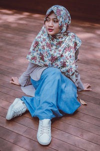 Low angle view of girl sitting on wooden floor