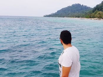 Man standing in sea against clear sky