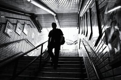 Full length rear view of woman standing on escalator