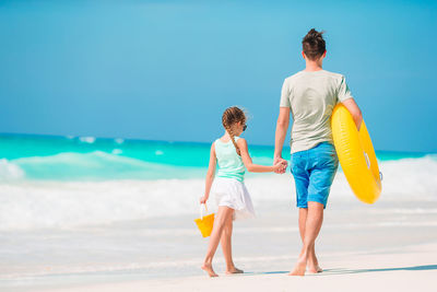 Rear view of boys standing on beach