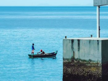 People in boat on sea against sky