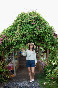 Portrait of woman standing against plants