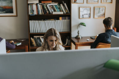 Young blond woman sitting in library