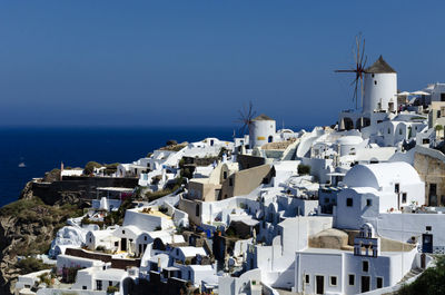 Buildings by sea against sky in city