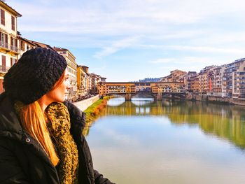 Woman looking at view of city against sky