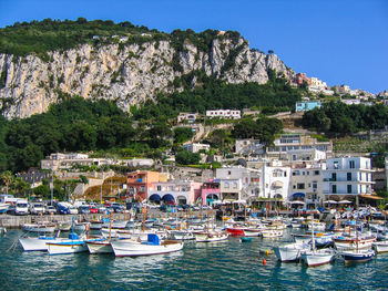 Boats in harbor by buildings in city