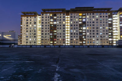 Buildings in city against clear sky at night