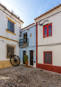 Houses by street against sky in city