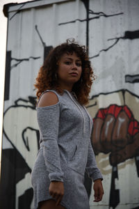 A young woman standing against a graffiti wall.

it's all inside of you. the fire within.