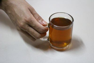 Close-up of hand holding beer glass