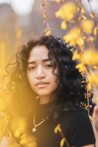 Portrait of young woman against plants