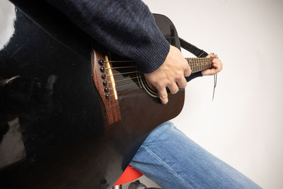 Midsection of man playing guitar