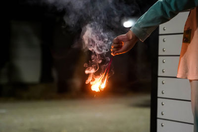 Midsection of man holding fire