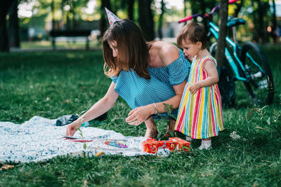 Full length of mother and daughter on grass