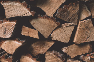 A stack of dry firewood logs laid in a heap stored for winter heating season background. 