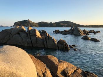 Rocks on shore against clear sky