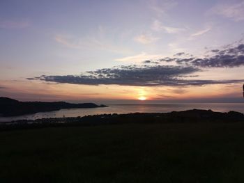 Scenic view of silhouette field against sky during sunset