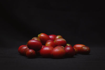 Close-up of tomatoes on table against black background