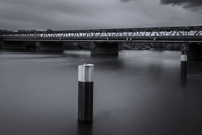 Bridge over river against cloudy sky