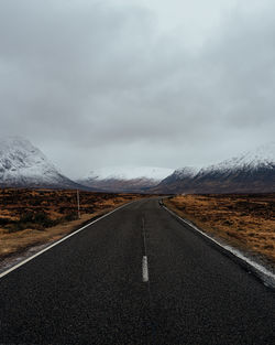 Road amidst field against sky