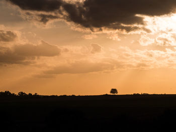 Scenic view of silhouette field against sky during sunset