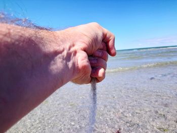 Close-up of man hand on beach