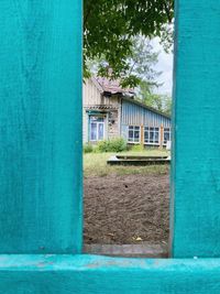 House against blue sky seen through window of building