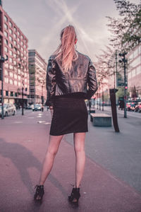 Midsection of woman standing on street in city