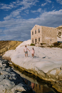 People on shore against sky